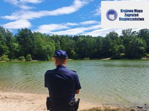 Policjant stojący nad zbiornikiem wodnym. W prawym roku logo i napis Krajowa Mapa Zagrożeń Bezpieczeństwa.