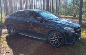 Pojazd marki Mercedes odzyskany przez policjantów. stojący w kompleksie leśnym.