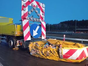 Uszkodzona przyczepka z strzałką drogową.