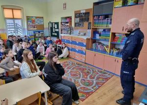 Policjant prowadzący spotkanie z uczniami.