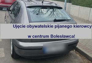 Szary samochód osobowy, w jego połowie widnieje na szarym tle granatowy napis &quot;Ujęcie obywatelskie pijanego kierowcy w centrum Bolesławca!&quot;