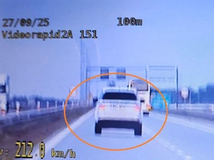 Screen z nagrania wideorejestratora, na którym widoczny jest tył białego pojazdu osobowego zakreślonego na pomarańczowo w kółko. Na zdjęciu widoczne są rożne liczby, w lewym dolnym roku wartość 212.