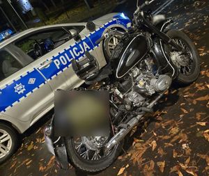 Czarnych motocykl na tle radiowozu.