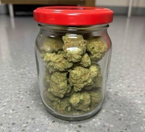 Zielone kulki w szklanym słoiku z czerwoną zakrętką