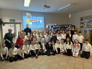 Dzielnicowy podczas spotkania z grupą uczniów.